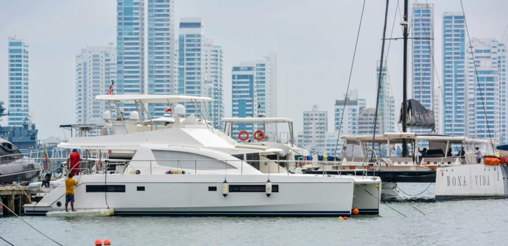 White yachts docked at a marina with a city's skyline in the background, embodying urban luxury.